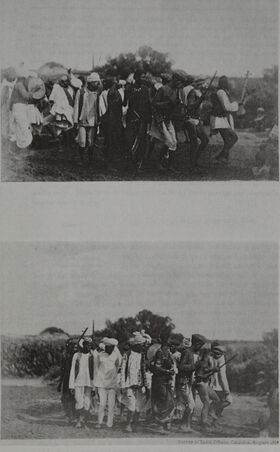 Two stacked photographs, each of a line of men in white moving together across open ground, holding on to one another as they tread.