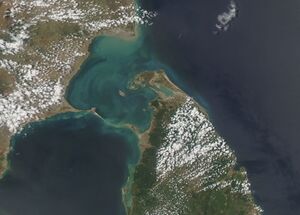 Satellite view of the southern tip of India and the north of Sri Lanka, with the shallow green waters of the strait between them and a chain of sandbanks across its southern end