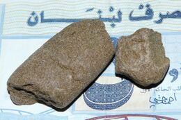 Two pressed slabs of hashish resting on a Lebanese banknote